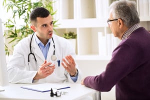 Elderly man discusses with doctor