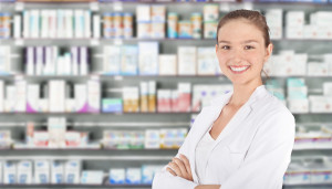 Young pharmacist smiling in front of medication