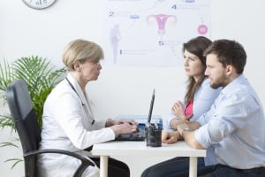 Couple sat at table discussing with doctor